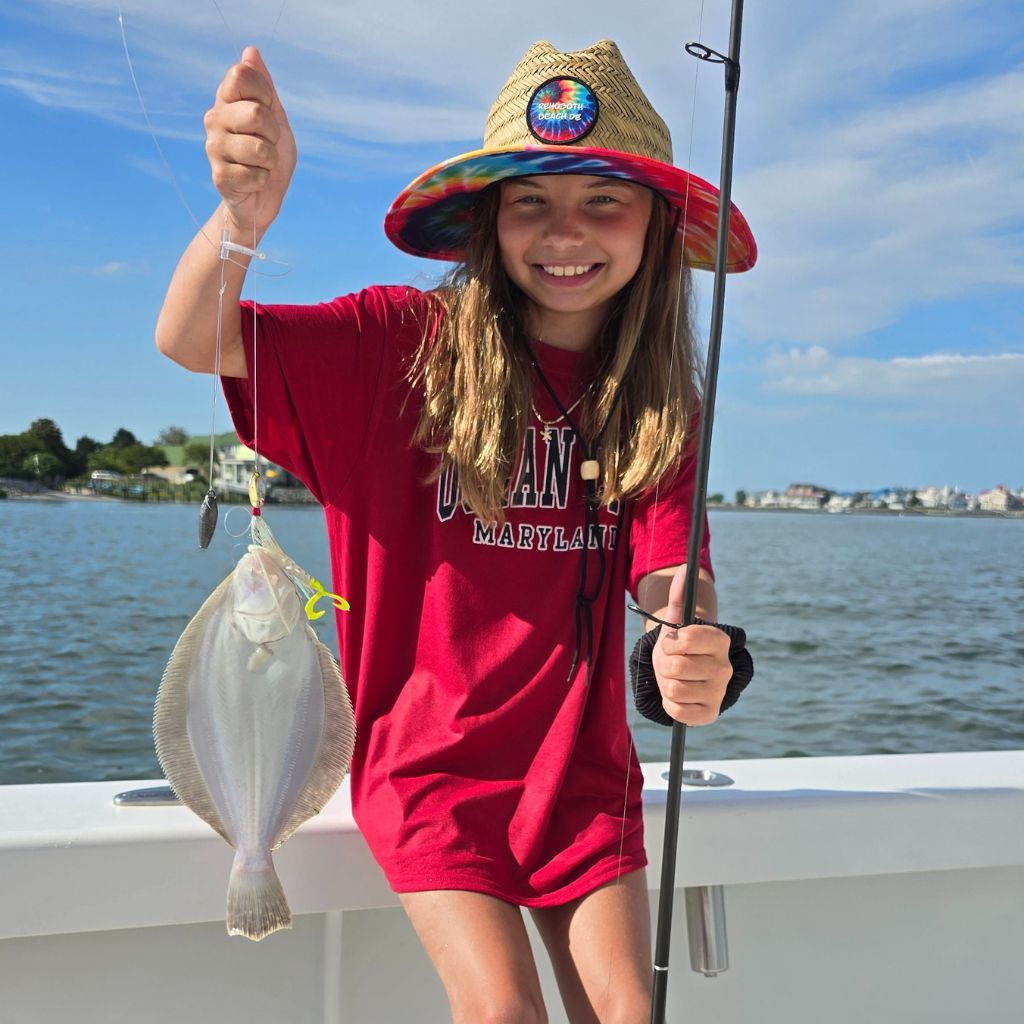 Young angler holding a flounder caught on a back bay fishing charter in Ocean City, Maryland