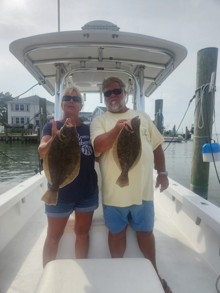 Couple holding flounder aboard center console boat during Ocean City Maryland charter
